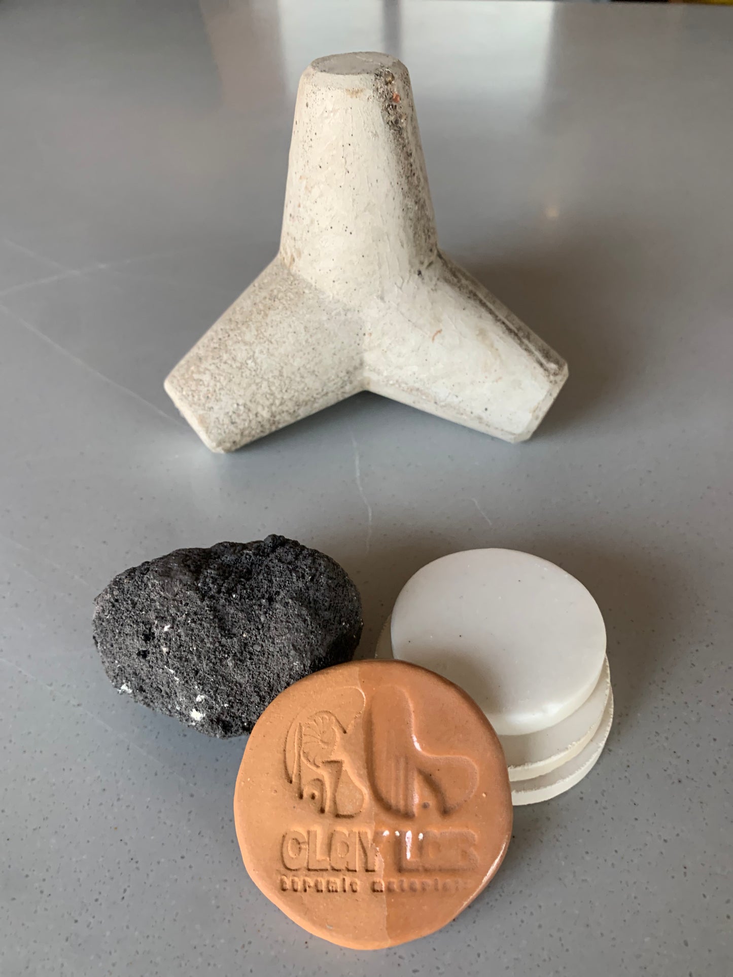 products made from light brown stoneware clay - white paperweight, black stone, white coins, etc