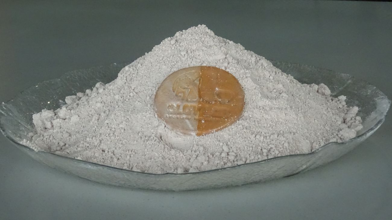 light brown clay powder with a coin made from it