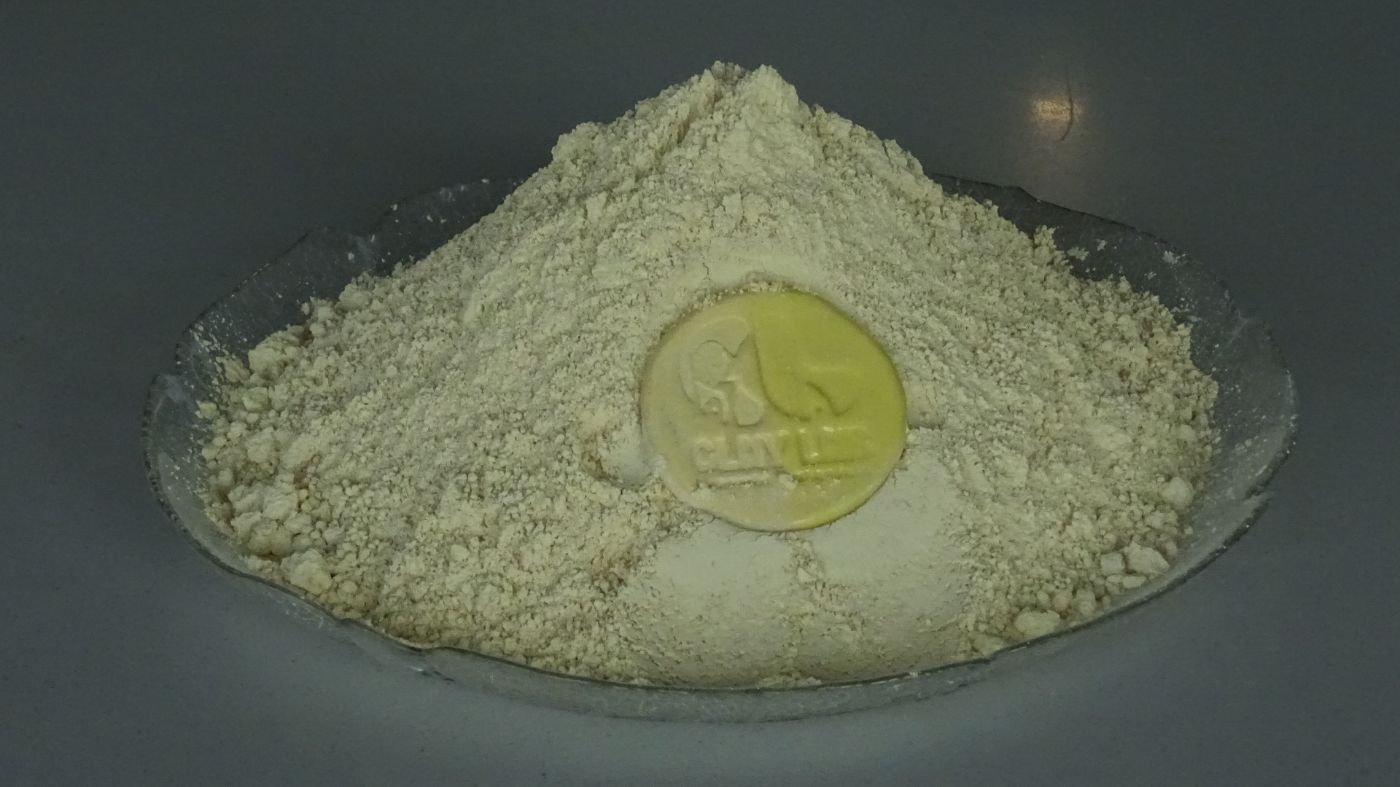 yellow colored clay kept in a plate with a coin on top 