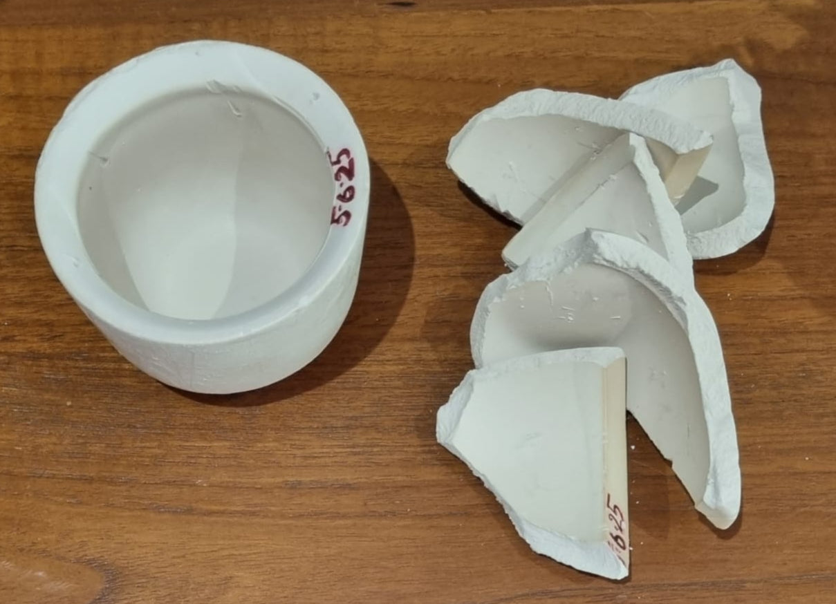 white ceramic cup with its pieces on the side