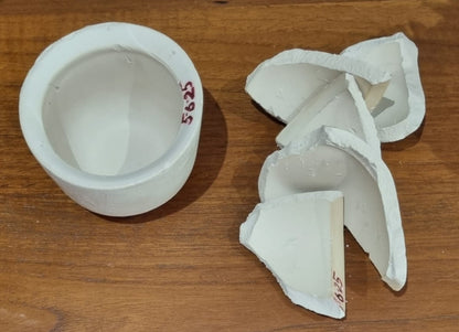 white ceramic cup with its pieces on the side